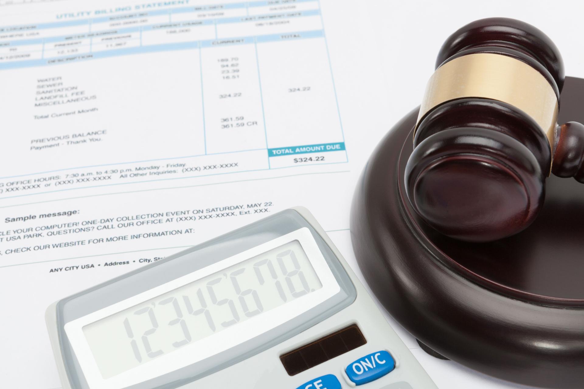Unpaid bill with calculator and wooden gavel over it series